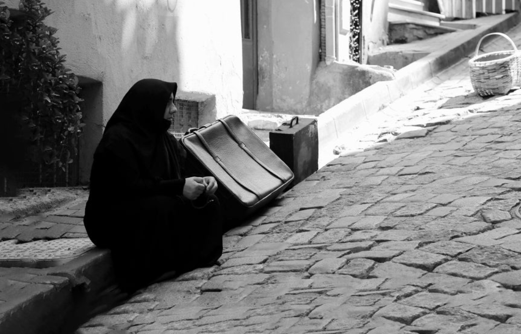 Waiting With a Suitcase: A Quiet Moment on a Stone Street